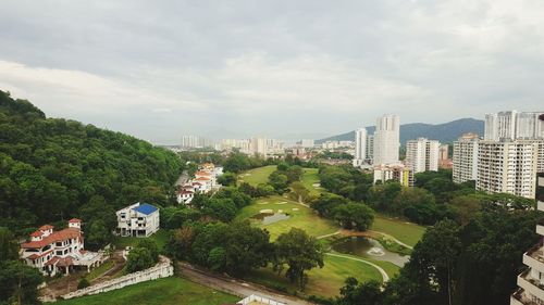 High angle view of city by sea against sky