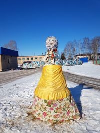 Woman with umbrella against clear blue sky