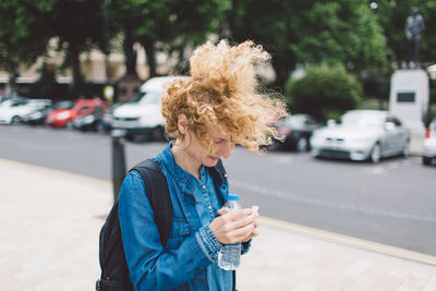 Woman with backpack standing on street