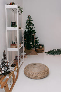 Christmas candles are lit on the shelves next to decorative christmas trees and books.