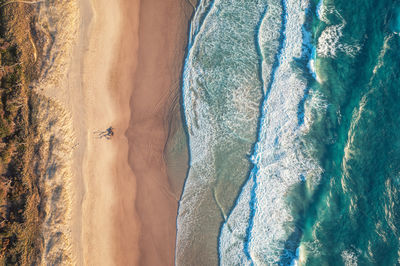 Top view of the ocean beach. calm seascape with white foam and sand. travel and leisure concept.