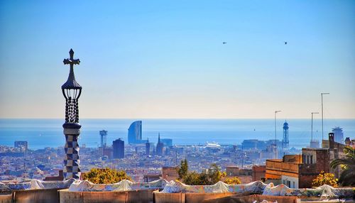 Cityscape by sea against clear sky