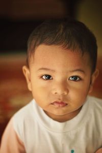 Portrait of cute boy sitting at home