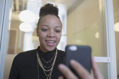 Young woman on her smart phone at the office.