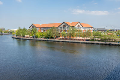 Houses on lake against blue sky