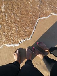 Low section of people standing on beach