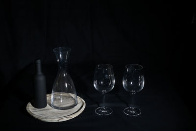 Wine glasses on table against black background