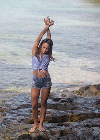 Full length of young woman standing at beach