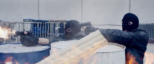 Criminals aiming guns while hiding behind barrels