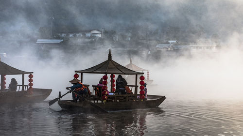 Man rowing boat on river during foggy weather