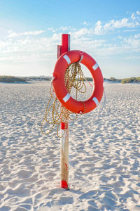 Red umbrella on beach against sky