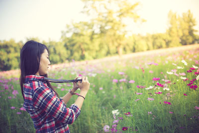 Woman photographing flowering plants