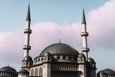 Low angle of famous taksim mosque with domes and minarets located against blue sky with pink clouds on street of istanbul, turkey