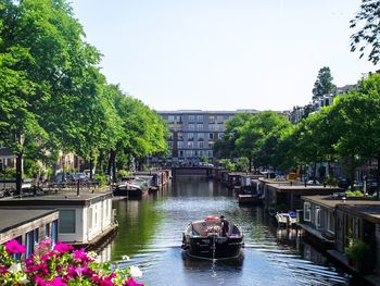 Boats on river against clear sky in city