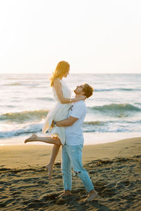 Rear view of woman standing at beach