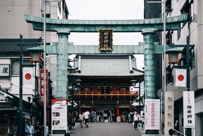 People walking on street against buildings in city