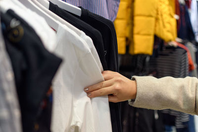 Cropped hand of woman shopping in clothing store