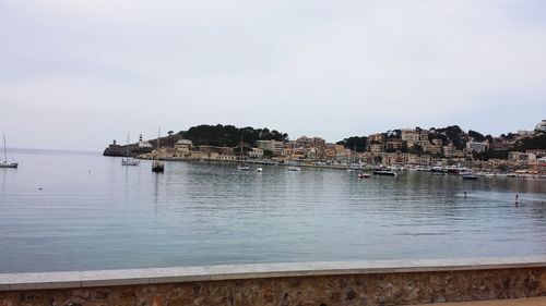 Scenic view of sea by buildings against sky