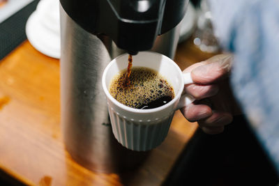 Cropped image of hand holding coffee cup