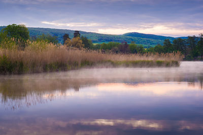 Scenic view of lake against sky at sunset