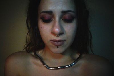 Close-up portrait of young woman against wall
