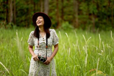 Young woman wearing hat standing on field