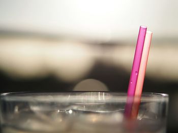 Close-up of iced water in glass with straws