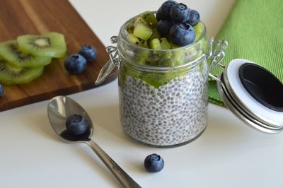 High angle view of breakfast on table - chia seed pudding topped with kiwi and blueberries 