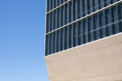 Low angle view of modern building against clear blue sky