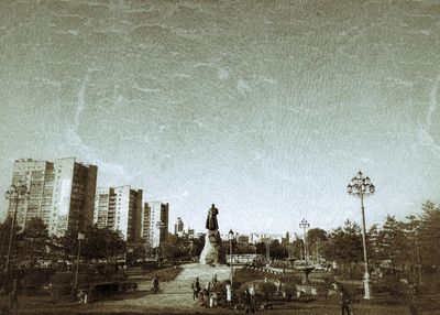 Digital composite image of statue against buildings in city