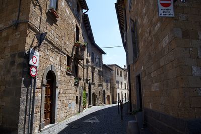 Low angle view of street amidst buildings