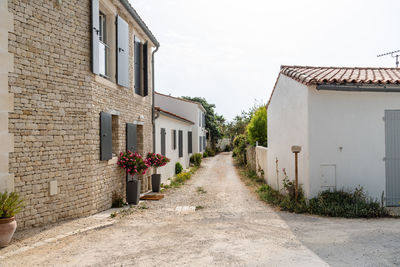 Footpath amidst buildings against sky