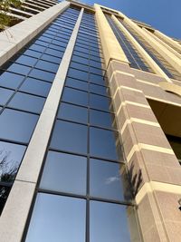 Low angle view of glass building against sky