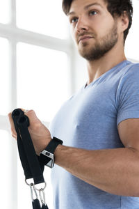 Portrait of young man exercising at home