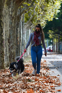 Full length of woman with dog during autumn