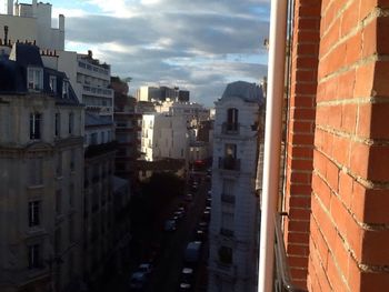 Buildings in city against cloudy sky