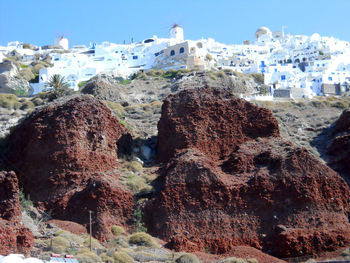 Rock formations by sea against clear sky