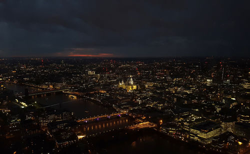 Aerial view of illuminated cityscape against sky at night