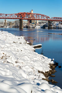 Broadway bridge over river against clear sky during winter