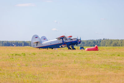 Airplane on field against sky