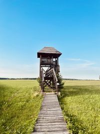 Lifeguard hut on field against sky