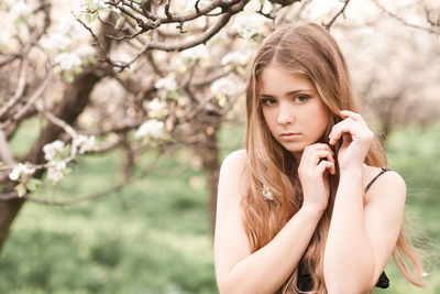 Teenager girl standing against cherry tree