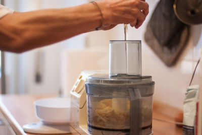 Cropped image of person pouring coffee in cup