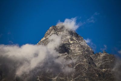 Low angle view of mountain peak against blue sky