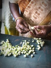 Midsection of woman holding flowers in market