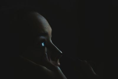 Close-up of human hand against black background