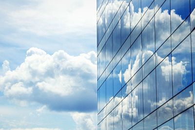 Low angle view of modern building against cloudy sky