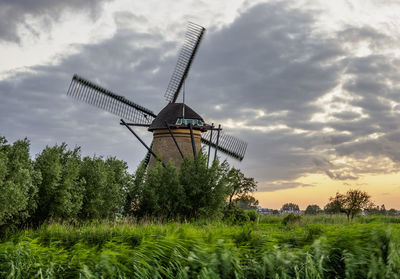 Traditional windmill on field against sky