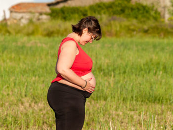 Pregnant woman standing on field