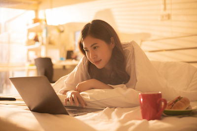 Young woman lying down on bed